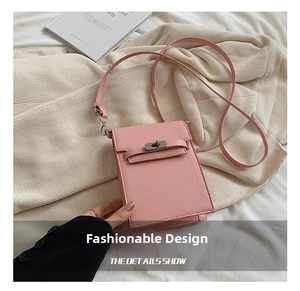 Detail shot of a pink crossbody phone bag with silver twist lock on faux leather