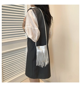 Detailed view of silver metallic tassel crossbody bag showing fringe and shoulder strap