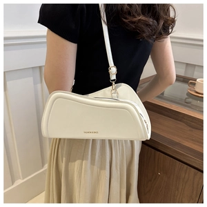 White minimalist underarm bag shown on model with polished synthetic leather and lettering