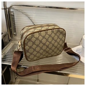 Gros plan détaillé du sac photo à motif trèfle avec bordure en cuir marron et boucles dorées