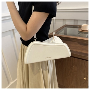 Detail of white leather shoulder bag with asymmetric arc shape and fashion text