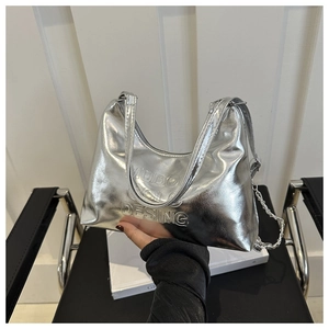 Detailed view of silver metallic bag with MUDO GOLC DESING embossing and chain detail
