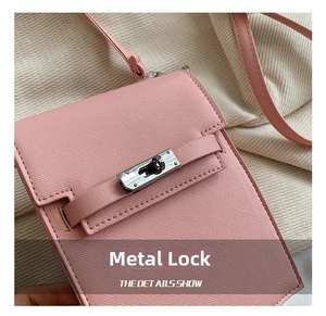 Detail of pink Saffiano leather mini bag featuring a silver hardware rotating clasp