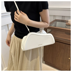 Close-up of a white irregular geometric shoulder bag with smooth PU leather finish