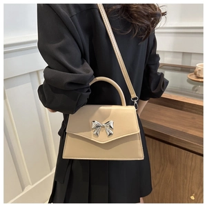 Elegant beige crossbody bag with silver bow accent and top handle for women
