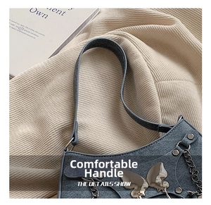 Detalle de bolso azul claro con lazo metálico, remaches y cadena de estilo moderno