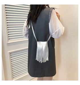 Silver fringe crossbody bag shown on a model highlighting the metallic tassel texture