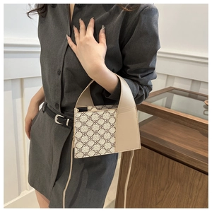 Schicke beige Handtasche mit Gittermuster und hellbraunem Lederbesatz an der Schulter