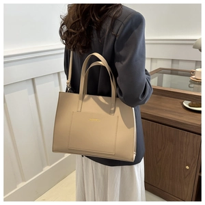 Detail of khaki PU leather tote bag with gold lettering and adjustable shoulder strap