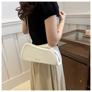 Detail shot of a white geometric shoulder bag with FASHION & BAGS text on model