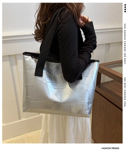 Detail of silver geometric patchwork tote bag with a wide black woven shoulder strap