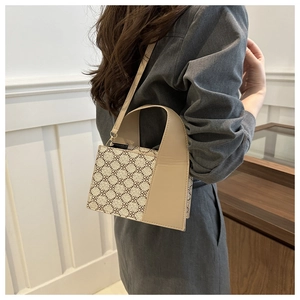 Detail einer schicken Handtasche in Creme und Khaki mit geometrischem Kleeblatt-Muster