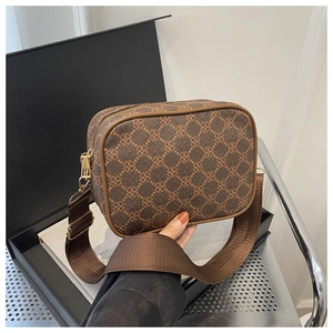 Gros plan du sac à bandoulière marron vintage avec motif trèfle et sangle large