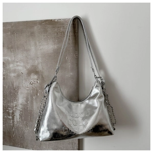 Detailed view of silver metallic tote bag with chain accents and embossed lettering