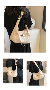 Detail of cream drawstring tote with pleated nylon texture and adjustable strap