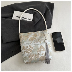 Détail de la broderie jacquard avec paysage chinois et breloque en pompon de soie