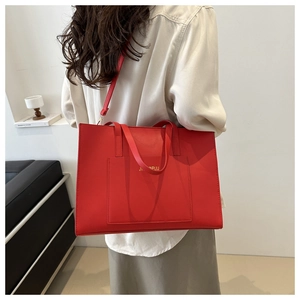 Model wearing a red vintage leather tote bag showing large capacity and shoulder strap