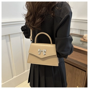 Chic beige bow small square bag shown from back view on model for style and scale