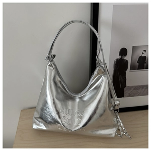 Detail of silver metallic tote bag featuring embossed logo and textured chain strap