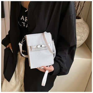 Detail of white cross-grain leather crossbody bag with silver rotating metal buckle closure