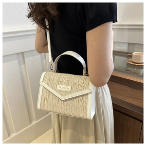 Détail du sac à bandoulière en paille beige avec garniture blanche et plaque Fashion