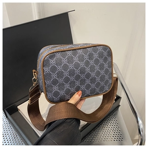 Détail du sac bandoulière gris-bleu à motif trèfle avec bordure marron et large sangle