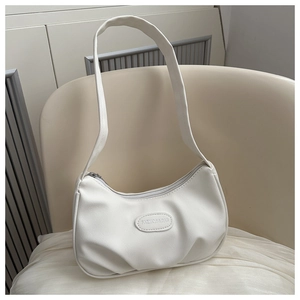 Detail shot of white pleated shoulder bag with embossed Fashion & Bag logo patch