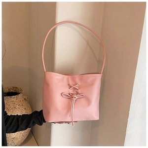 Detail view of pink PU leather shoulder bag featuring a decorative laced-up bow design