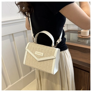 Detail of white leather and straw woven crossbody bag with Fashion logo and gold hardware