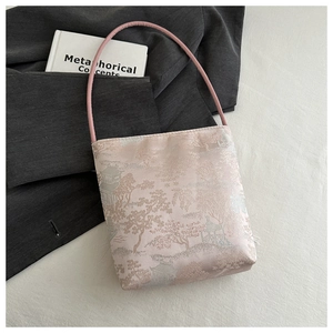 Gros plan du tissu jacquard rose avec broderie traditionnelle chinoise sur un sac à main