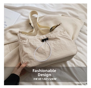 Detail of beige pleated nylon shoulder bag with drawstring and wide adjustable strap