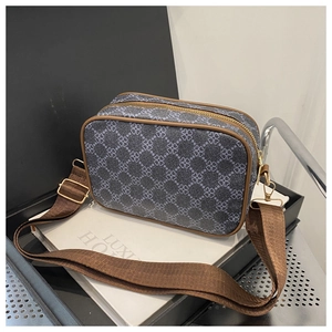Détail du sac jacquard vintage avec bordure en cuir marron et fermetures éclair dorées