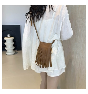 Detailed back view of a retro dark brown tassel crossbody bag on a model