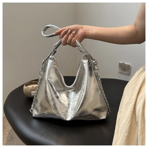 Detail of silver metallic hobo bag featuring embossed lettering and chain strap design