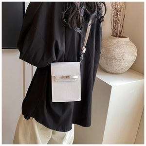 Detailed view of white mini crossbody bag with cross-grain texture and metal turn-lock closure