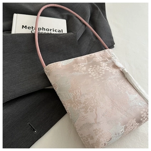 Nahaufnahme der rosa orientalischen Beuteltasche mit Brokatmuster und weißer Seidenquaste