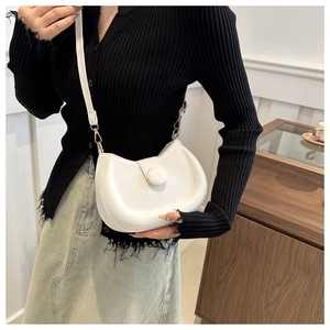 Detail of a minimalist white half-moon crossbody bag in smooth PU leather with round buckle