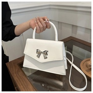 Elegant white leather handbag with silver bow clasp for shoulder and crossbody wear
