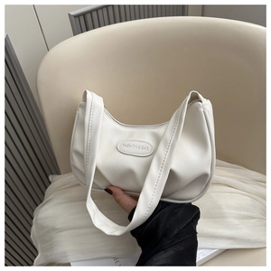Detail of white pleated hobo bag featuring silver oval fashion logo and smooth faux leather