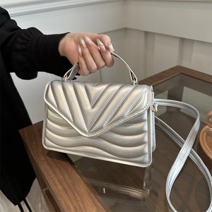 Silver quilted envelope shoulder bag with metallic finish and adjustable strap