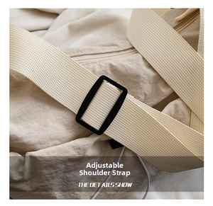 Detail view of the adjustable high-density nylon shoulder strap on the cream tote bag