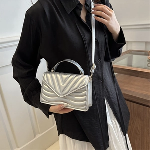Silver metallic mini crossbody bag with V-shaped quilting and adjustable strap