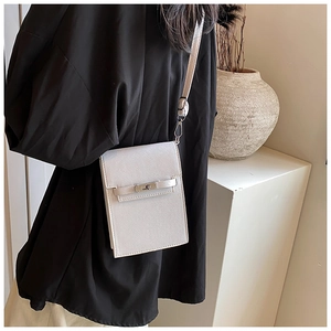 Detail of white cross-grain leather mini phone bag featuring a metal twist lock clasp
