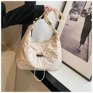 Detail of cream crescent tote bag with pleated nylon texture and adjustable drawstring