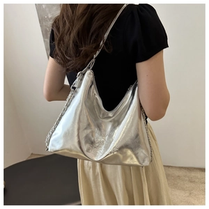 Detail of silver metallic tote bag with embossed text and elegant chain shoulder strap