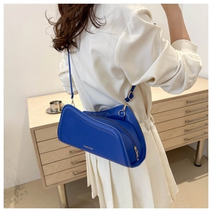 Detail of dark blue crescent shoulder bag with metallic zipper and fashion branding