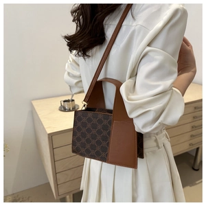 Detailaufnahme einer braunen Retro-Umhängetasche mit geometrischem Muster und Griff