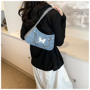 Bolso de hombro denim azul con apliques de mariposa blancos y cadena de plata