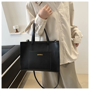 Detailed view of black leather tote bag with gold JINGPINPIJU lettering and crossbody strap