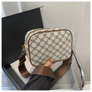 Détail du sac photo avec motif monogramme, large bandoulière et ferrures dorées